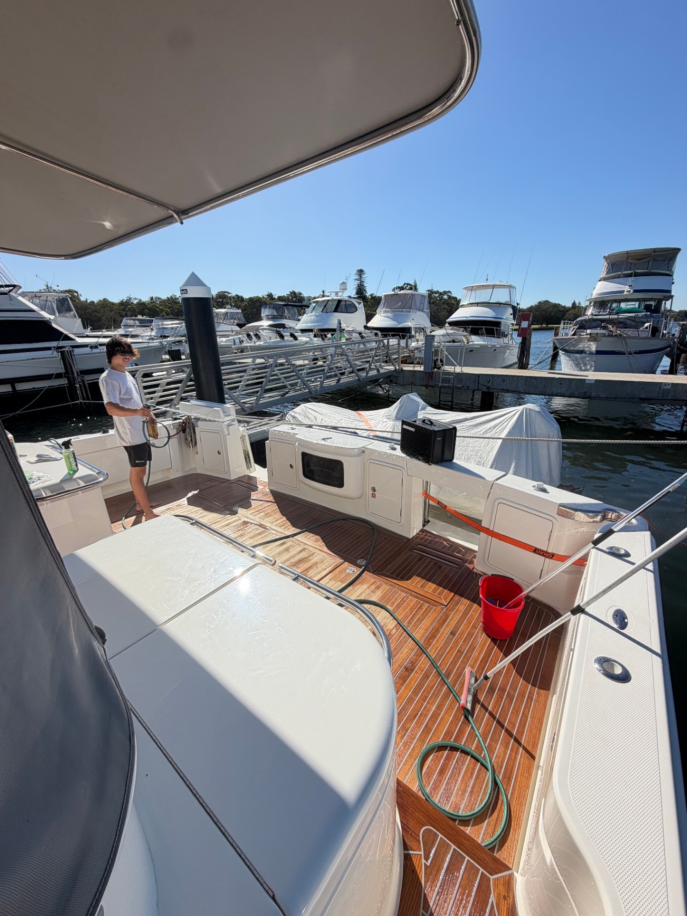 Teak deck wash in progress at the marina